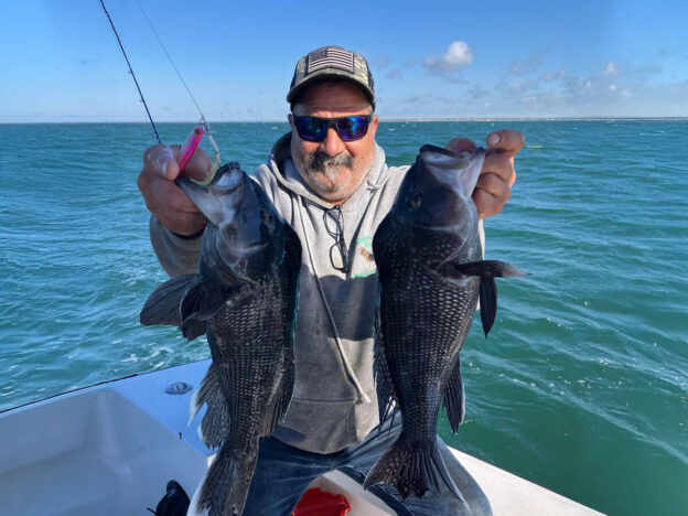 A man proudly holding fish on a boat, representing healthy outdoor activities, accomplishment, and enjoying life in recovery.